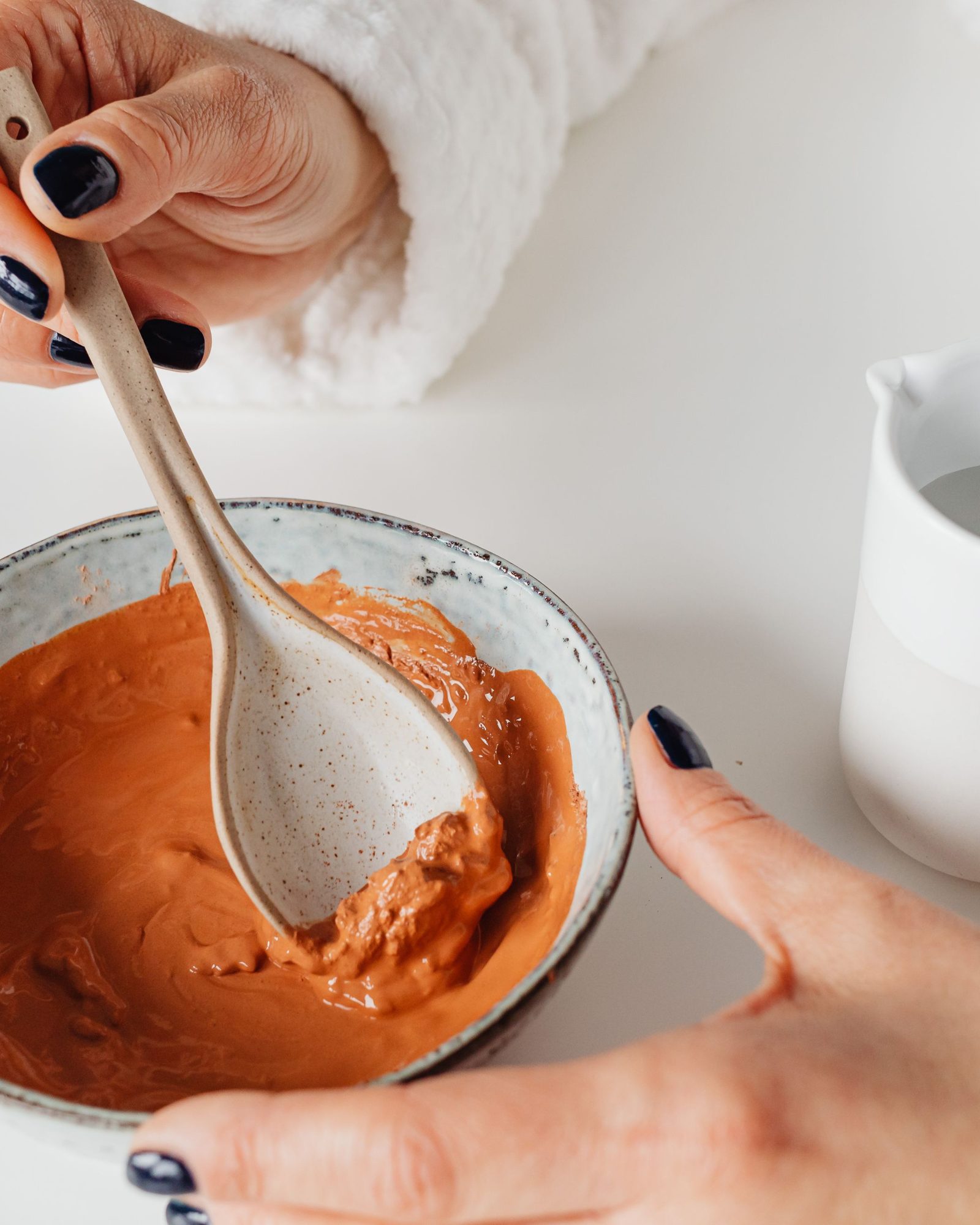 Mains appliquant une crème naturelle sur une peau sensible du visage